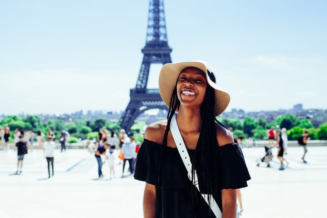 Woman standing behind Eiffel tower