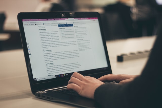 A person typing on a laptop computer