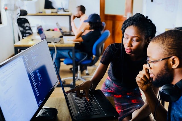 A man and a woman looking at a computer screen