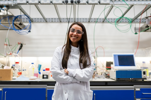 A woman in white lab coat smiling