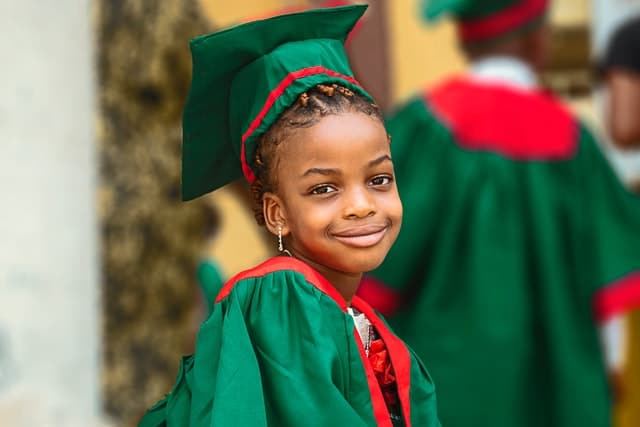 A kid wearing graduation gown