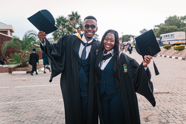 Two students wearing graduation gown