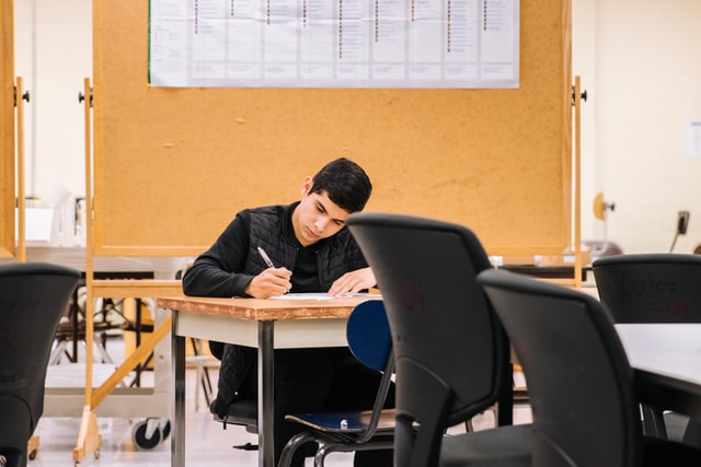 Man in black long sleeve shirt sitting on a chair