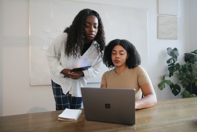 Female colleagues collaborating with a surface in a board