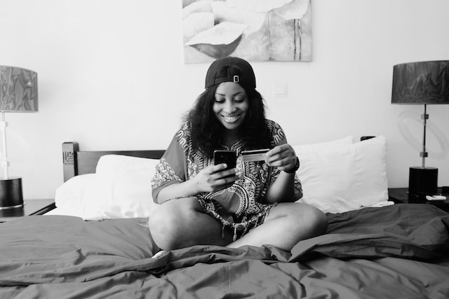 Woman sitting on the bed holding her phone